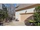 Attached two-car garage with a beige door, sitting alongside a concrete driveway and wooded backyard at 155 Georgetown Woods Dr, Youngsville, NC 27596