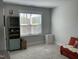 Comfortable bedroom with a red loveseat, built-in shelving, and a view from the window at 1585 Lavington Pl, Apex, NC 27502