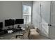 Bright office space with modern desk setup, accent chair and footrest, and natural light streaming through the window at 1585 Lavington Pl, Apex, NC 27502