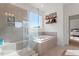 Luxurious bathroom featuring separate tub, shower, tiled walls, and decorative shelving creating a spa-like experience at 169 Hidden Bluff Dr, Chapel Hill, NC 27517