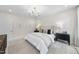 This neutrally decorated bedroom boasts an elegant chandelier and ample natural light at 1800 Bright Lantern Way, Wendell, NC 27591
