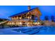 Stunning clubhouse and pool area, beautifully lit at dusk, featuring a modern architectural design and inviting amenities at 1800 Bright Lantern Way, Wendell, NC 27591