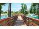 A wooden dock extends into a tranquil pond with a fountain, offering scenic views of nearby homes at 1800 Bright Lantern Way, Wendell, NC 27591