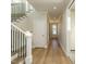 Bright entryway featuring hardwood floors, white trim, and staircase with black metal railing at 1800 Bright Lantern Way, Wendell, NC 27591