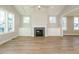 Spacious living room featuring a fireplace, large windows, and beautiful wood floors at 1800 Bright Lantern Way, Wendell, NC 27591