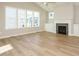 Spacious living room featuring a fireplace, large windows, and beautiful wood floors at 1800 Bright Lantern Way, Wendell, NC 27591