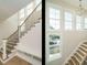 Bright staircase featuring wood treads, white risers, black metal railing, and multiple windows at 1800 Bright Lantern Way, Wendell, NC 27591