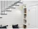 Elegant staircase with black metal railings and a cozy built-in bench seat, lit by a stylish gold sconce at 1800 Bright Lantern Way, Wendell, NC 27591