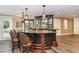 Well-stocked wet bar features custom lighting, granite countertop, ample storage, and seating for four at 1801 Oatlands Ct, Wake Forest, NC 27587