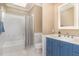 Bathroom with a blue vanity, bathtub, and a shower, with white tiles and wainscoting at 1801 Oatlands Ct, Wake Forest, NC 27587