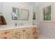 Bathroom vanity with a mirror, decorative cabinetry, and a window with white shutters at 1801 Oatlands Ct, Wake Forest, NC 27587
