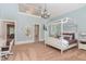 Spacious bedroom featuring a canopy bed, chandelier, and an open balcony overlooking the room at 1801 Oatlands Ct, Wake Forest, NC 27587