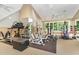 Large home gym with mirrored walls, workout equipment, a rubber floor, a large window, and ceiling fans at 1801 Oatlands Ct, Wake Forest, NC 27587