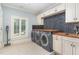 Spacious laundry room with front loading washer and dryer, custom cabinets, and a butcher block countertop at 1801 Oatlands Ct, Wake Forest, NC 27587