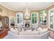 Bright living room with a fireplace, chandelier, large windows, and elegant decor at 1801 Oatlands Ct, Wake Forest, NC 27587