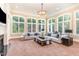 Bright living room featuring large windows, neutral furnishings, and a decorative chandelier at 1801 Oatlands Ct, Wake Forest, NC 27587