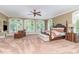 Expansive main bedroom with four-poster bed, sitting area, large windows, and neutral decor at 1801 Oatlands Ct, Wake Forest, NC 27587