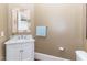 Lovely powder room with a marble vanity top, white cabinets, decorative mirror, and a towel rack at 1801 Oatlands Ct, Wake Forest, NC 27587