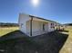 The backyard is large and open with a covered patio and a clear blue sky overhead at 181 Tulipfield Way, Benson, NC 27504