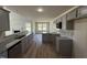 Modern kitchen featuring gray cabinets, granite countertops, and stainless appliances open to the living room at 181 Tulipfield Way, Benson, NC 27504