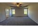 A large main bedroom featuring a tray ceiling, ceiling fan, and ample natural light at 181 Tulipfield Way, Benson, NC 27504