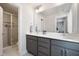 Modern bathroom featuring a double vanity with gray cabinets, quartz countertops, and a glass-enclosed shower at 1903 Plott Balsam Dr, Wendell, NC 27591