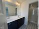 Bathroom featuring double sinks, a shower with glass door, and striking floor tile at 1903 Plott Balsam Dr, Wendell, NC 27591