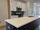 Modern kitchen with an island, white cabinets, and stainless steel appliances at 1903 Plott Balsam Dr, Wendell, NC 27591
