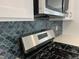 Close-up of a gas range with stainless steel appliances and a mosaic backsplash at 1903 Plott Balsam Dr, Wendell, NC 27591