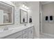 Stylish bathroom with double vanity, decorative mirrors, modern lighting, and mosaic tiled accent wall at 193 Jenny Ln, Timberlake, NC 27583