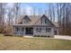 Charming home featuring a stone accent base, gray siding, dormers, and a welcoming front porch at 193 Jenny Ln, Timberlake, NC 27583