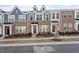 Modern townhomes featuring brick facades and varying neutral color accents create a cohesive streetscape at 235 Chesapeake Commons St # 86, Garner, NC 27529