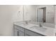 A well-lit bathroom with a double sink vanity, mirror, and open doorway to an adjoining space at 2562 Summersby Dr, Mebane, NC 27302
