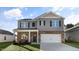 Charming two-story home with gray siding, brick accents, and a well-manicured lawn at 2562 Summersby Dr, Mebane, NC 27302