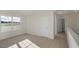 Open loft area with neutral carpeting, bright window, and doorway at 2562 Summersby Dr, Mebane, NC 27302