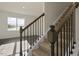 Carpeted staircase features decorative iron spindles and stained wood banister at 2562 Summersby Dr, Mebane, NC 27302