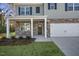Up close view of a new two-story home featuring stone accents, a covered porch and a two-car garage at 2573 Summersby Dr, Mebane, NC 27302