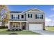 New two-story home featuring gray siding, stone accents, black shutters and a two-car garage at 2573 Summersby Dr, Mebane, NC 27302