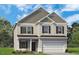 Charming two-story home featuring a two-car garage, neutral siding, and a well-manicured lawn at 27 Meath Ct # 215, Clayton, NC 27520