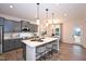 Modern kitchen with grey cabinets, a large island, pendant lighting, and stainless steel appliances at 27 Meath Ct # 215, Clayton, NC 27520