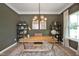 Stylish home office with a wooden desk, shelving, decor, rug, chandelier and ample natural light at 27 Meath Ct # 215, Clayton, NC 27520