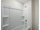 Bathroom tub and shower combination featuring built-in shelves and a white surround at 2735 Luxborough Ln, Mebane, NC 27302
