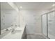 Bathroom showcasing double sinks with quartz countertops and a frameless glass shower at 2735 Luxborough Ln, Mebane, NC 27302