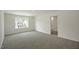 Bright carpeted bedroom featuring a door leading to the bathroom and a large window at 2735 Luxborough Ln, Mebane, NC 27302