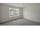 Bedroom features neutral carpet and paint, and a large double-hung window overlooking the neighborhood at 2735 Luxborough Ln, Mebane, NC 27302