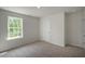 Bedroom featuring a large window, neutral carpet, and a white door at 2735 Luxborough Ln, Mebane, NC 27302