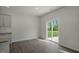 Dining room with hardwood floors, white walls, and sliding glass door to the backyard at 2735 Luxborough Ln, Mebane, NC 27302