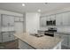 Well-lit kitchen with gray cabinetry, stainless steel appliances, granite countertops, and a large center island at 2735 Luxborough Ln, Mebane, NC 27302