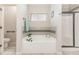 Bathroom features a soaking tub, glass enclosed shower, and neutral toned tile work at 32 Colson Dr, Garner, NC 27529