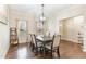 Elegant dining room featuring hardwood floors, a modern chandelier, and a formal dining table set for six at 32 Colson Dr, Garner, NC 27529